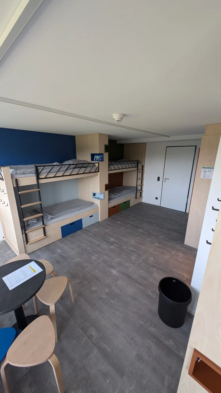 Mehrbettzimmer mit Etagenbett, Stauraum und offenem Eingangsbereich – Evangelische Gesellschaft für Deutschland KdöR