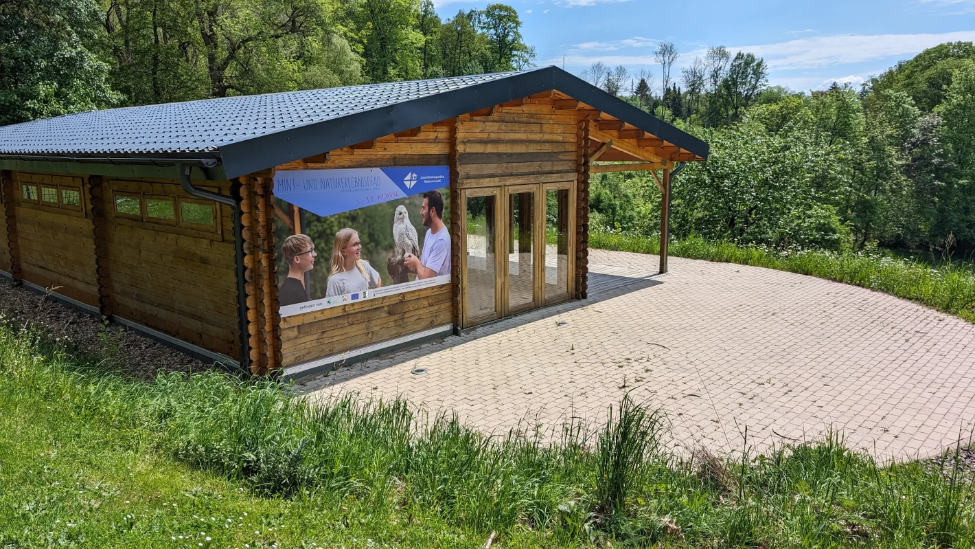 Kleines Holzhaus mit Veranda und großen Fenstern, eingebettet in die Natur – Evangelische Gesellschaft für Deutschland KdöR