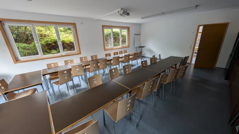 Konferenzraum mit langen Tischen und vielen Stühlen, Blick zu den Fenstern – Evangelische Gesellschaft für Deutschland KdöR