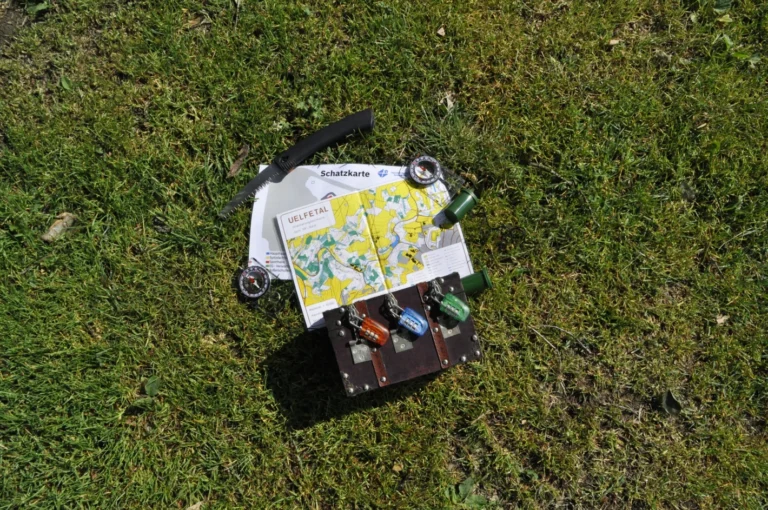 Vogelperspektive auf ein kleines Fahrzeug oder Objekt im Gras mit ausgebreiteter Karte darauf – Evangelische Gesellschaft für Deutschland KdöR