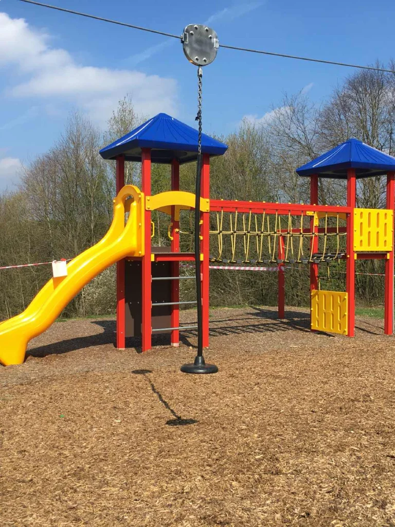 Spielplatz mit Klettergerüst, Rutsche und Holzschnitzelboden im Freien – Evangelische Gesellschaft für Deutschland KdöR